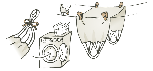 Una ilustración que muestra que la tela de la silla colgante se puede lavar en la lavadora y luego colgar para secar en un tendedero